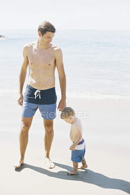 Man and son wearing swimming trunks — Stock Photo