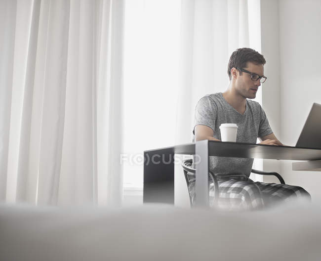 Uomo seduto a un computer portatile — Foto stock