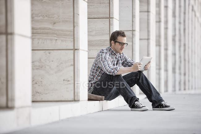 Мужчина расслабляется и проверяет телефон — стоковое фото