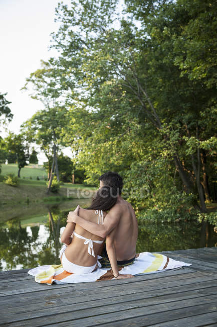 Хлопчик і дівчинка, що сидить на дерев'яні jetty — стокове фото
