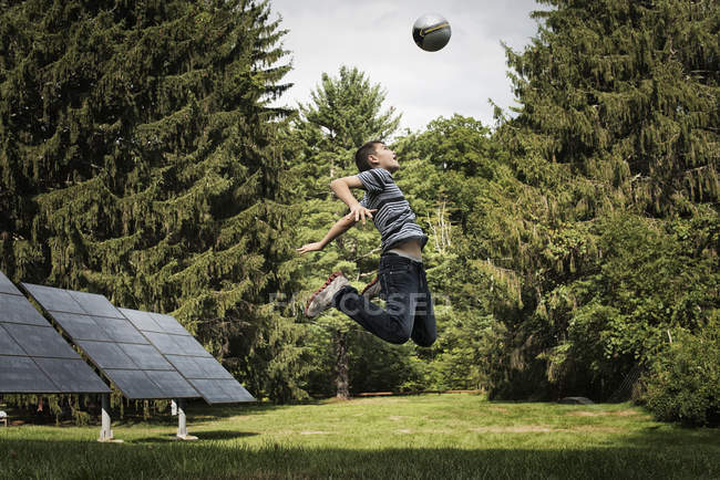 Хлопчик стрибає на голову м'яч . — стокове фото