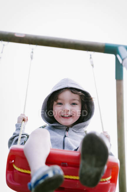 Хлопчик сидить на гойдалці — стокове фото