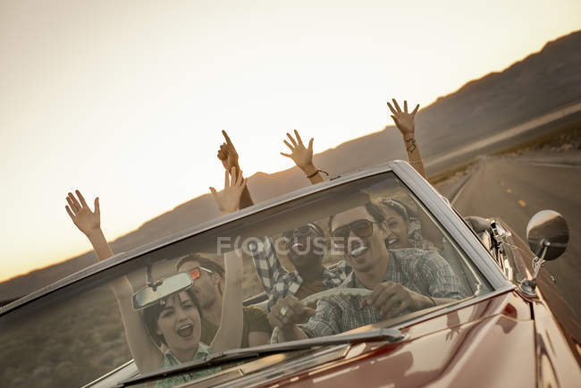 Amis en voiture convertible sur un road trip . — Photo de stock