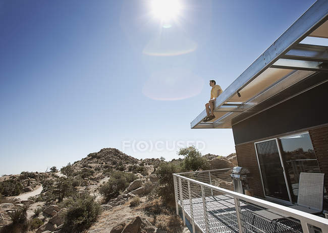 Homem sentado no telhado — Fotografia de Stock
