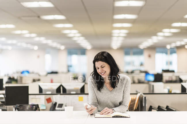 Femme assise à un bureau — Photo de stock