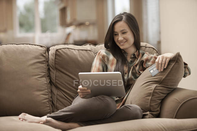 Femme avec tablette numérique et carte de crédit — Photo de stock