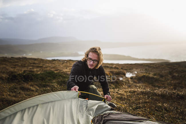 Man feeding a tent pole — Stock Photo