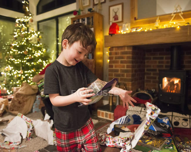 Junge eröffnet Geschenke am ersten Weihnachtsfeiertag — Stockfoto