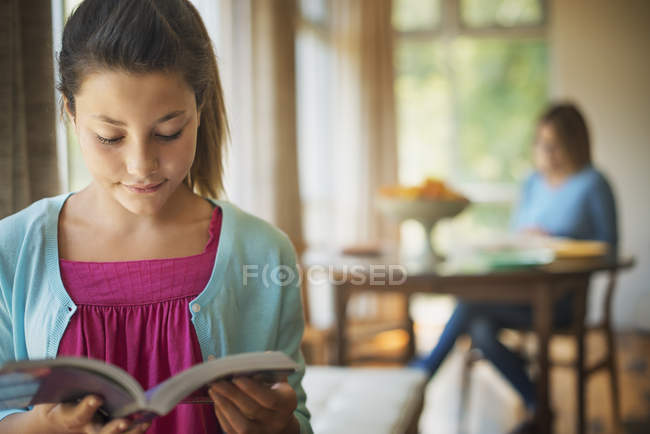 Chica joven leyendo un libro - foto de stock