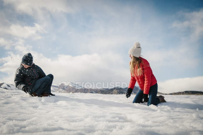 Irmão e irmã brincando na neve . — Fotografia de Stock