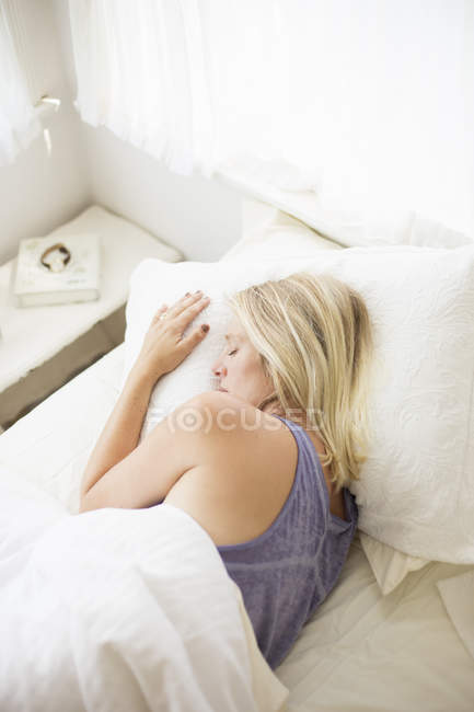 Femme dormant dans un lit — Photo de stock