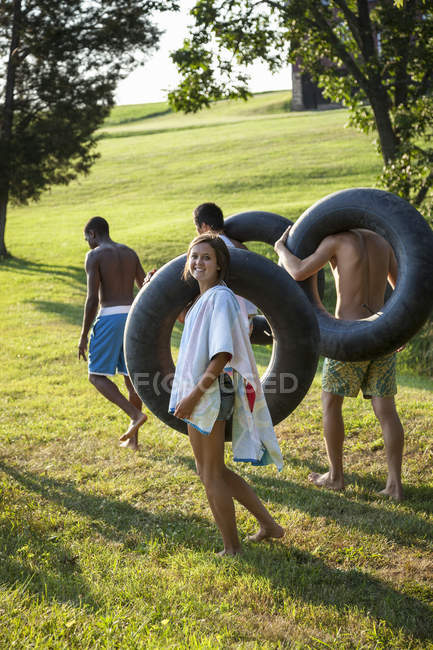 Niños y niñas, sosteniendo toallas y flotadores de natación - foto de stock