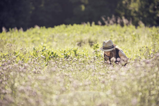 Chica en sombrero de paja en un prado - foto de stock