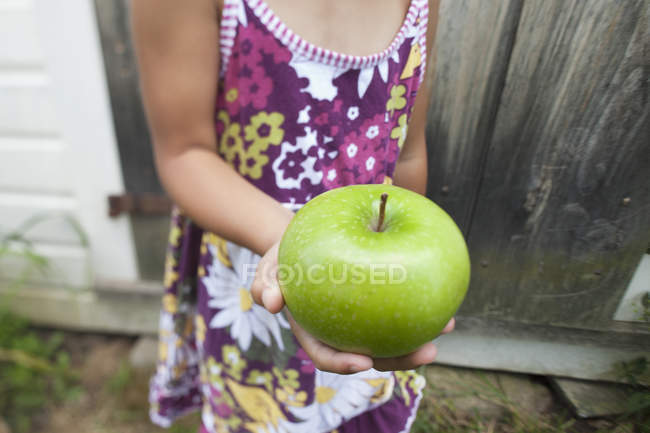 Child holding green apple — Stock Photo