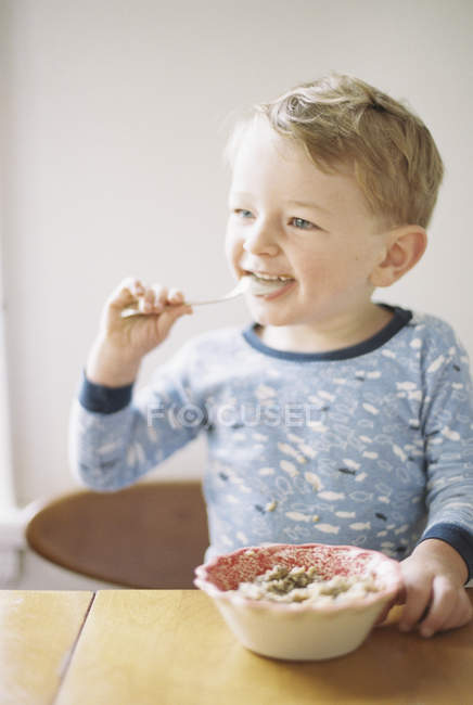 Junge isst Frühstück aus einer Schüssel. — Stockfoto