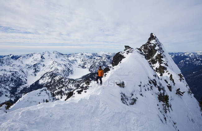 Esquiador en una ridgeline, haciendo una pausa antes de esquiar - foto de stock