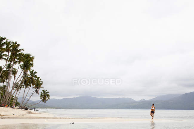 Mujer en una playa aislada - foto de stock