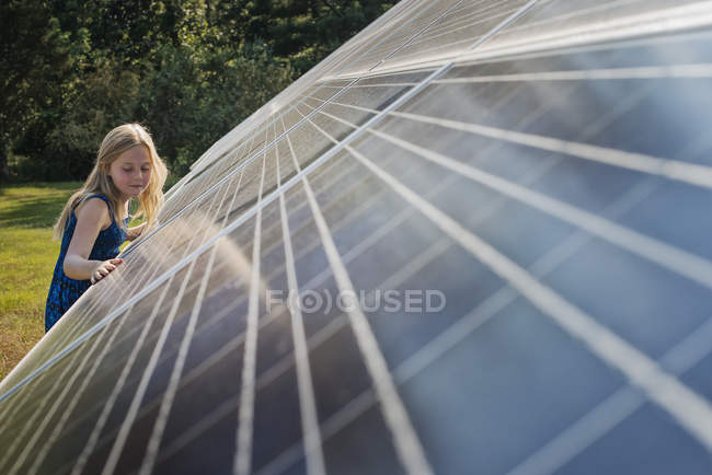 Chica joven al lado del panel solar - foto de stock
