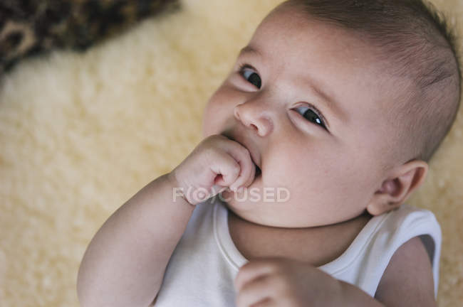 Baby girl with her hand in her mouth — Stock Photo