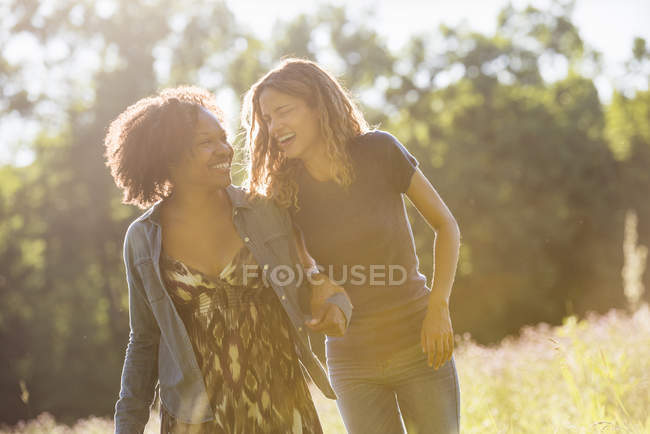 Две женщины, идущие через поле — стоковое фото
