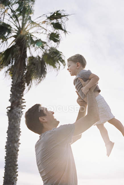 Hombre levantando hijo en el aire
. - foto de stock