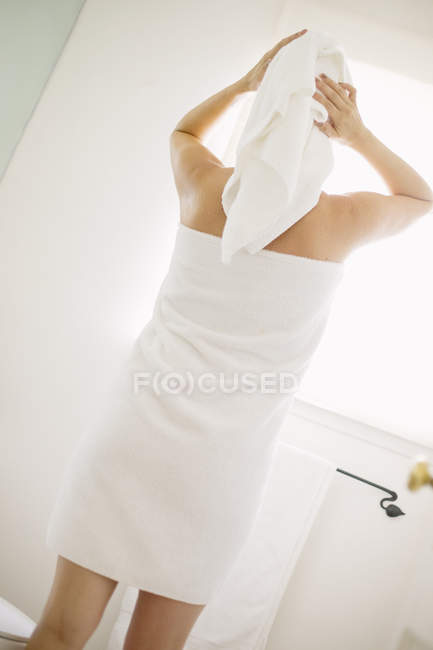 Donna in asciugamano bianco in un bagno — Foto stock