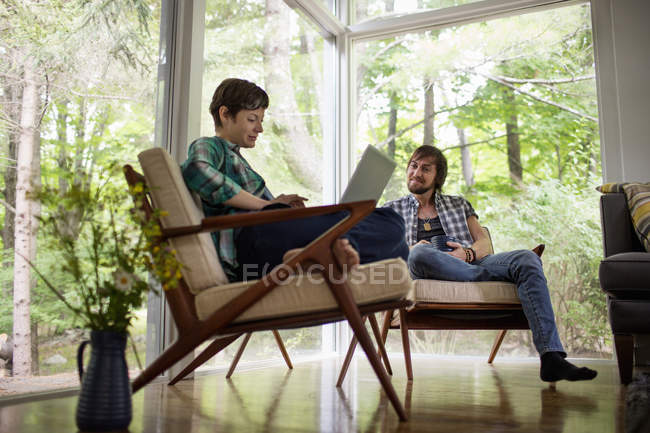 Hombre y mujer sentados juntos - foto de stock