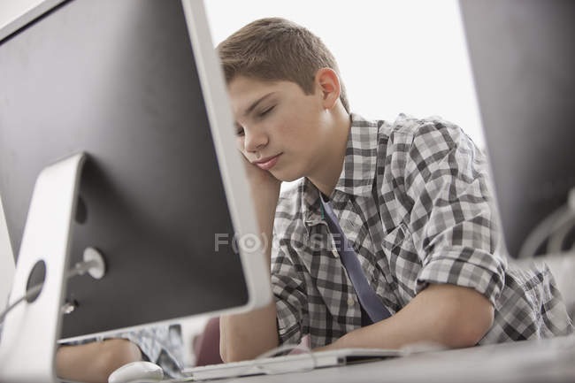 Boy sitting with his hand on his chin — Stock Photo