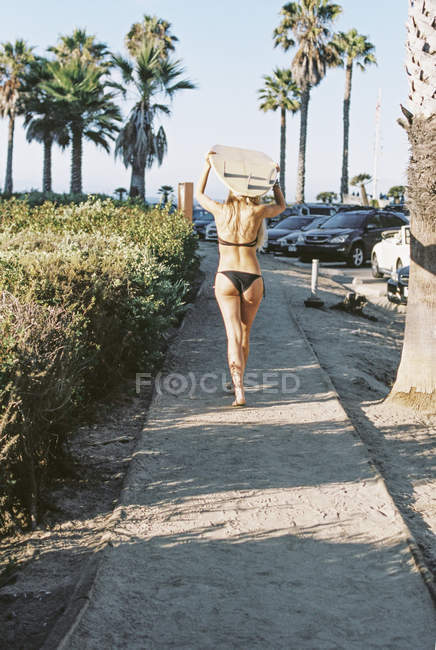 Mulher carregando um surfboar — Fotografia de Stock
