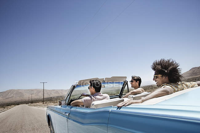 Young people in a pale blue convertible — Stock Photo