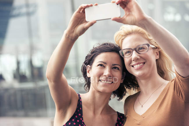 Mulheres em uma rua de cidade, tirando uma selfie — Fotografia de Stock