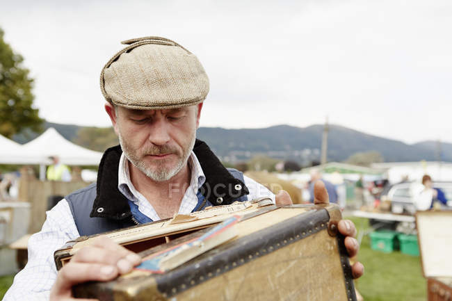 Чоловік дивиться на старовинну валізу — стокове фото
