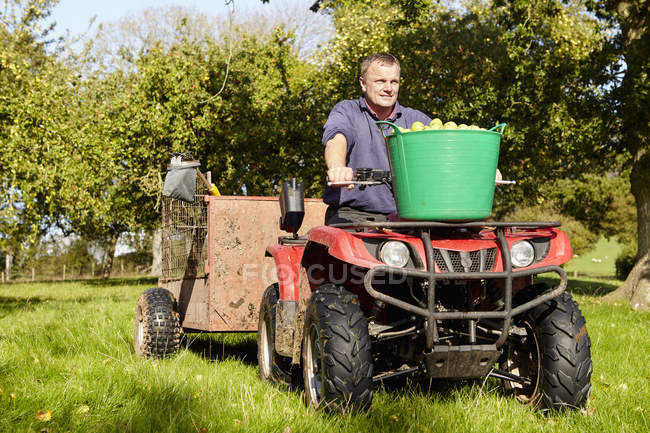 Man driving a quad bike and trailer — Stock Photo