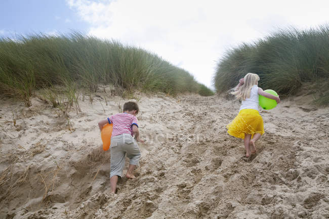 Menino e menina correndo embora areia — Fotografia de Stock