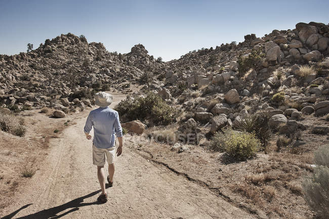 Man walking along rocky landscape — Stock Photo