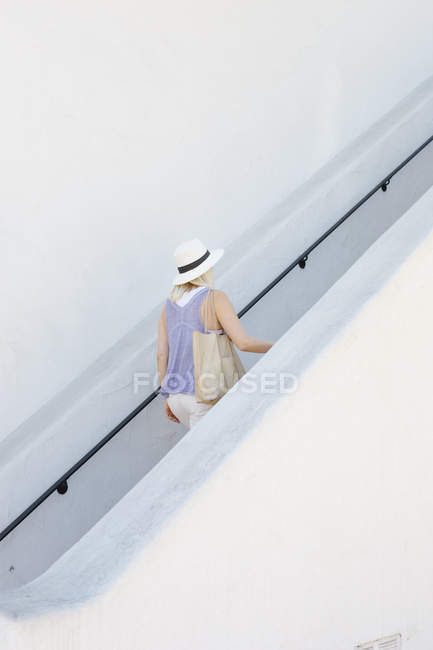 Blond woman walking up a staircase. — Stock Photo