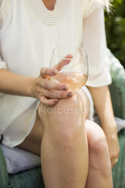 Donna che tiene un bicchiere di vino rosato. — Foto stock
