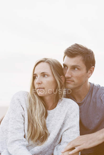 Casal sentado perto de uma praia — Fotografia de Stock