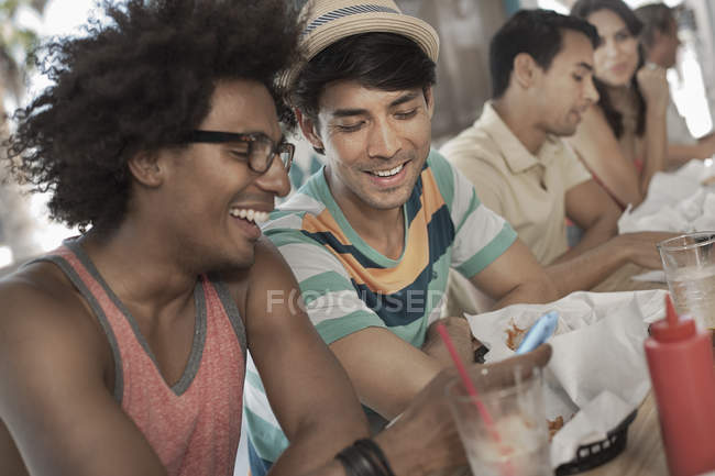 Four friends seated in a diner. — Stock Photo