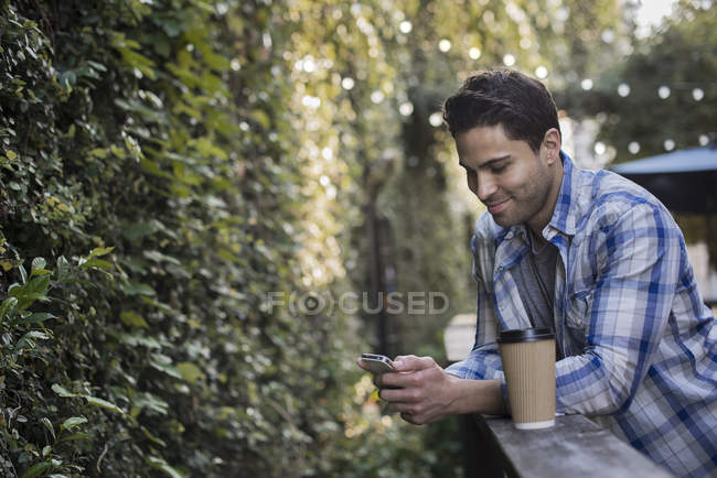 Hombre usando su teléfono en la cafetería - foto de stock