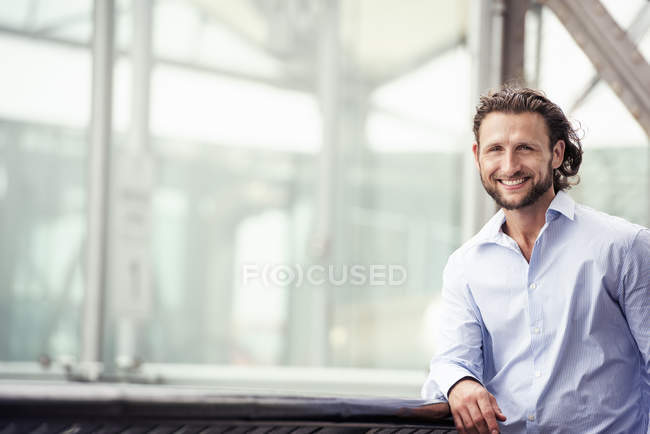 Man standing outdoors leaning on a windowsill — Stock Photo
