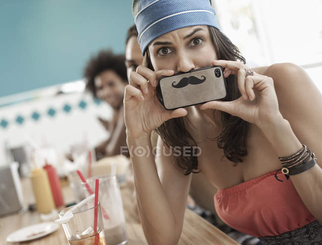 Mulher segurando uma foto de um bigode — Fotografia de Stock