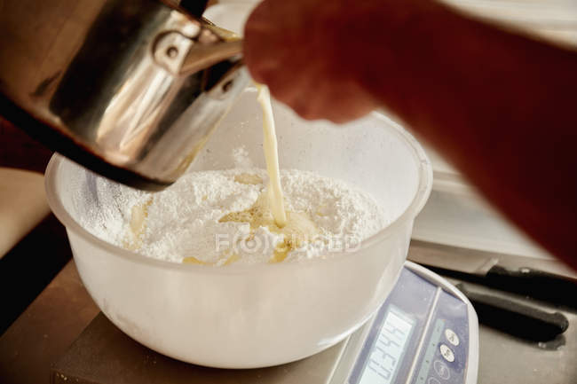 Baker pouring liquid from jug — Stock Photo