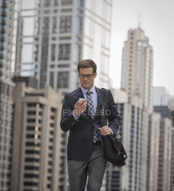 Businessman checking his phone on street — Stock Photo
