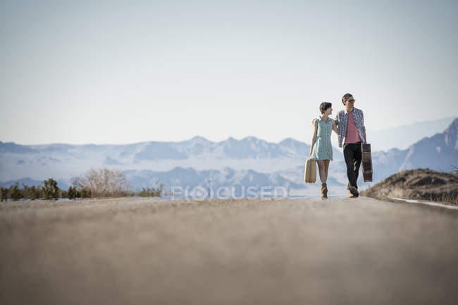 Couple sur une route goudronnée dans le désert — Photo de stock