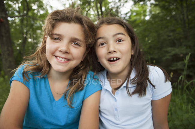 Meninas sentadas lado a lado — Fotografia de Stock