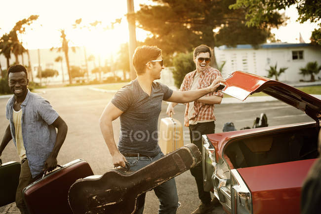 Freunde packen Auto mit Koffern und Gitarre — Stockfoto