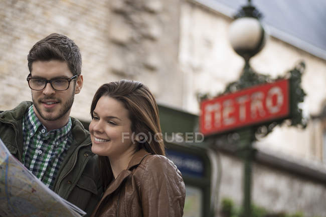 Casal consultar um mapa em uma rua da cidade — Fotografia de Stock