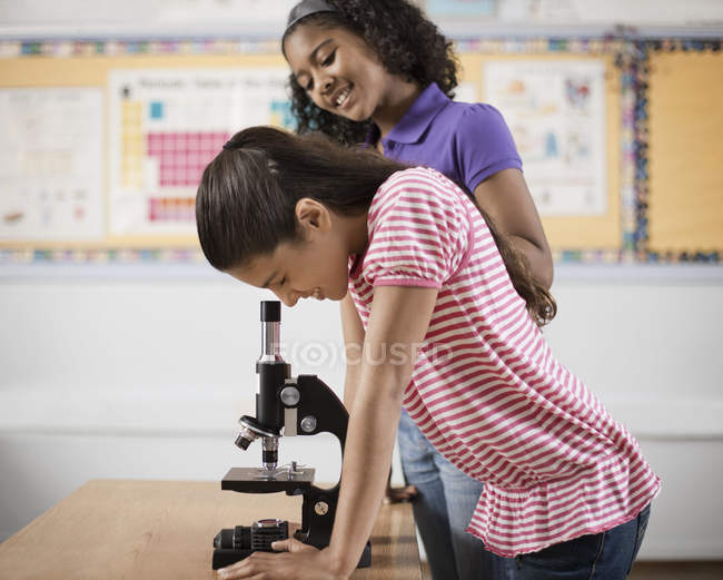 Двое детей с помощью микроскопа — стоковое фото