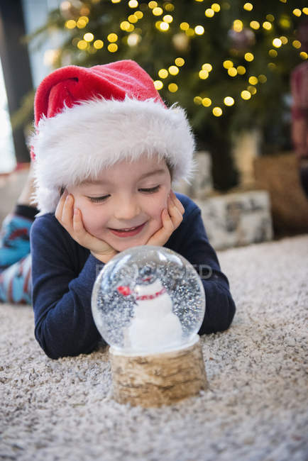Niño con globo de nieve de cristal - foto de stock